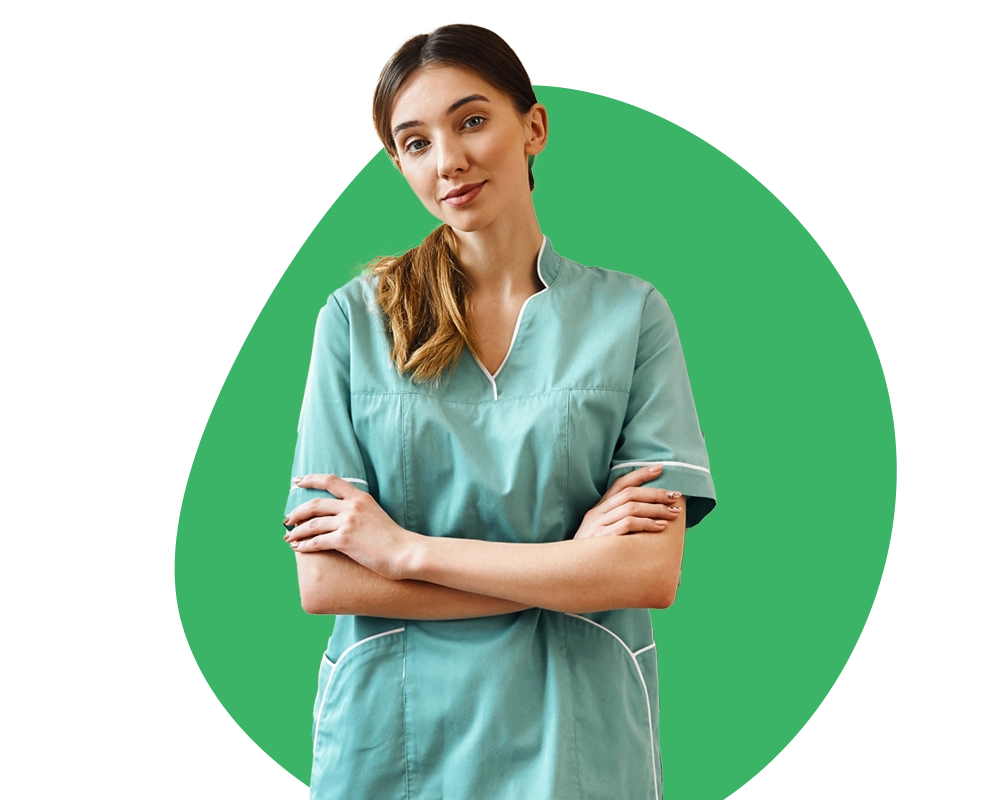 Enfermera con uniforme verde, brazos cruzados y sonriendo.